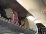 (فیلم) خوابیدن یک زن در محفظه بالای سر مسافران هواپیما!